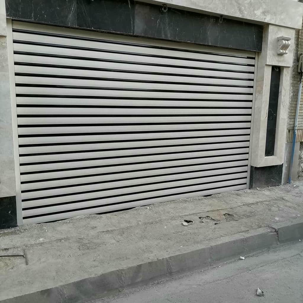 کرکره برقی پارکینگ خودرو ساختمان با شفت نصب شده بالای دهانه کرکره برقی پارکینگ خودرو ساختمان با شفت نصب شده بالای دهانه