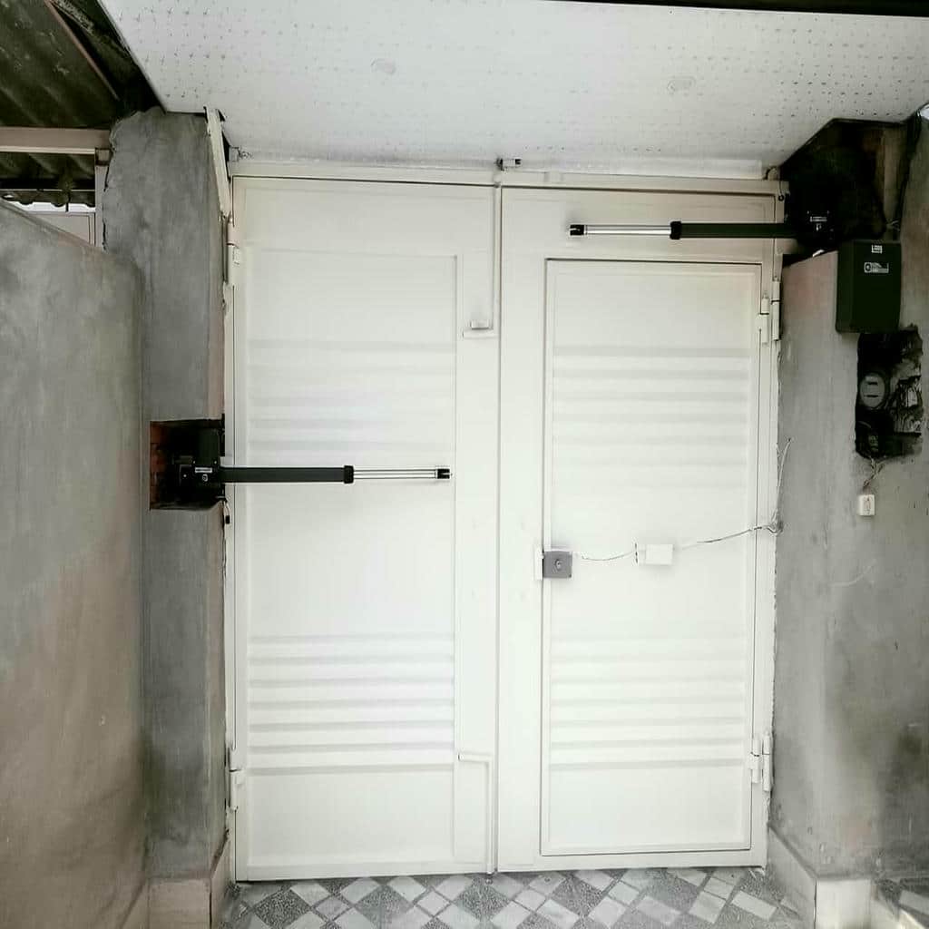 بازوی خاکستری کنار قفل دروازه حیاط