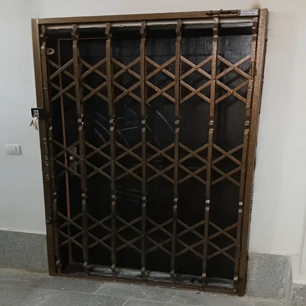 حفاظ درب آکاردئونی مشکی روی ورودی قدیمی مشهد