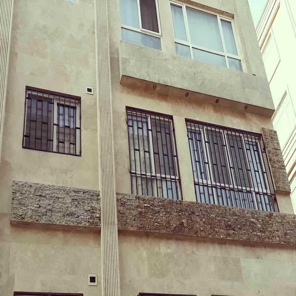 حفاظ پنجره آهنی طوسی با میله‌های عمودی منظم