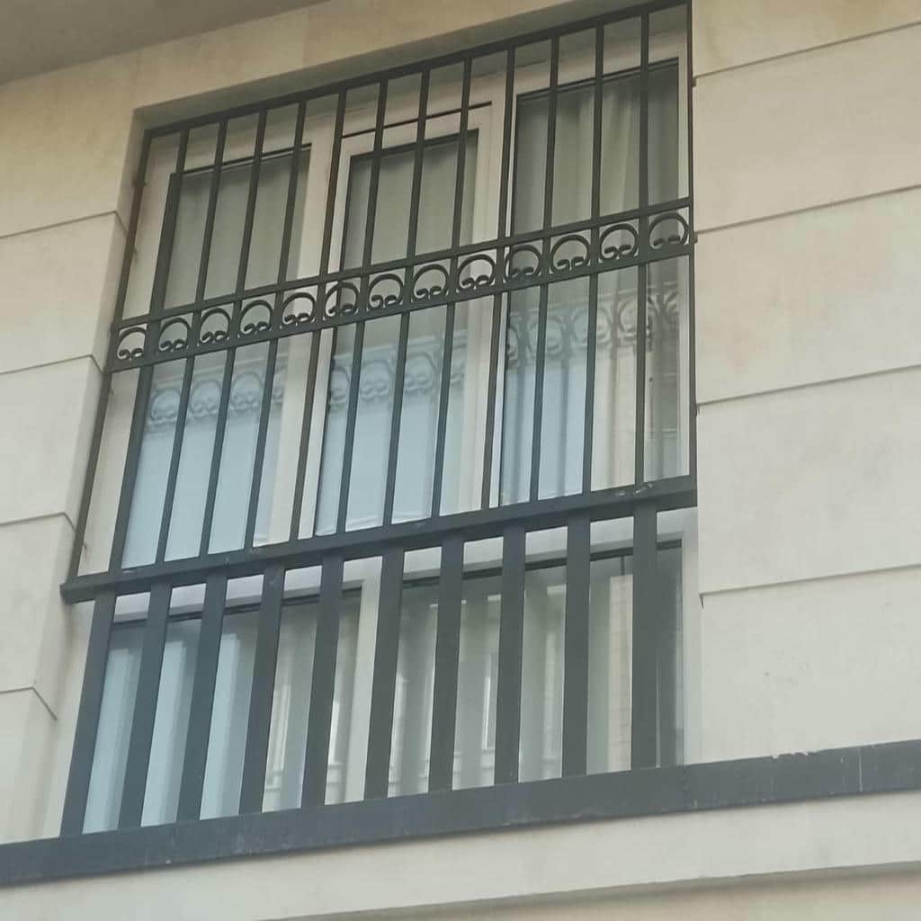 حفاظ پنجره عمودی باریک روی نمای آجری روشن