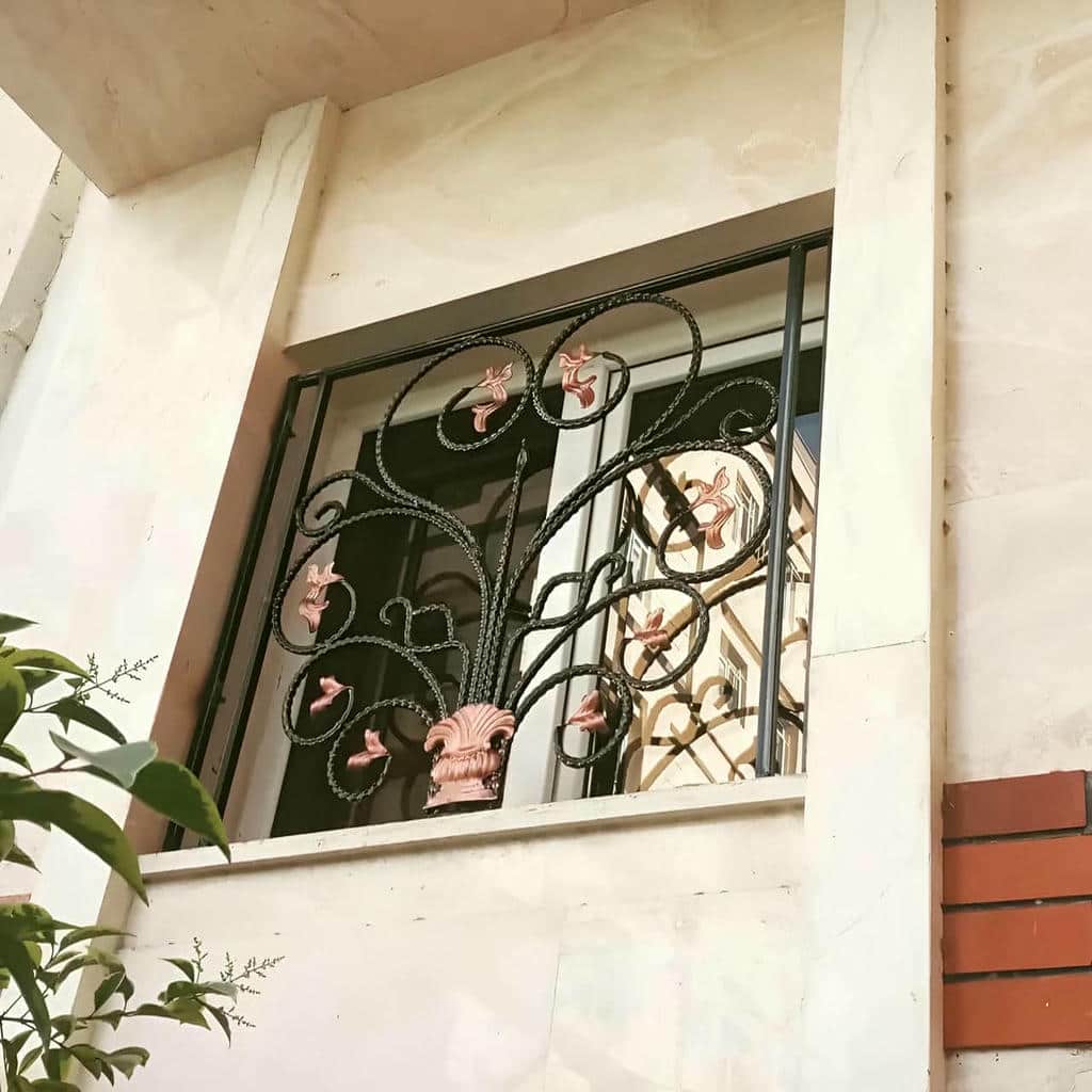 نرده آهنی خاکستری کنار قاب سنگی ایلام