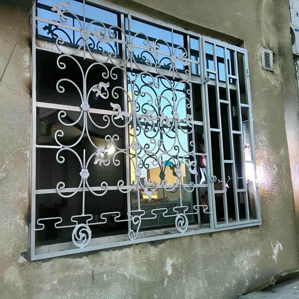 نرده پنجره مشکی در ساختمان بازسازی شده با نمای سنگی نرده پنجره مشکی در ساختمان بازسازی شده با نمای سنگی