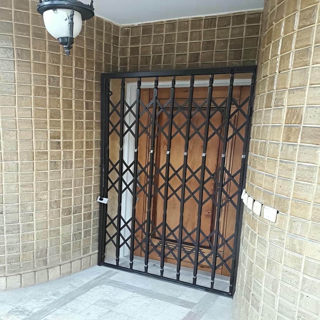 نمای نزدیک قفل توکار روی شبکه کشویی برنزی